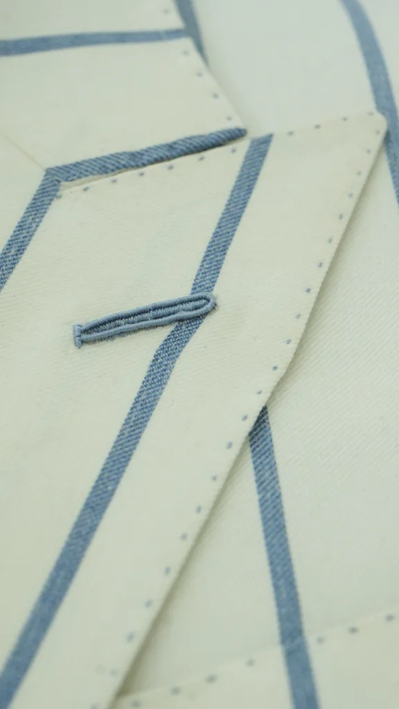 Close-up detail of a finished handmade Milanese buttonhole with silk sheen on bespoke suit lapel by Laxmi Bespoke Tailor