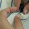 Master tailor hand-stitching a Milanese buttonhole on bespoke suit lapel at Laxmi Bespoke Tailor Jakarta